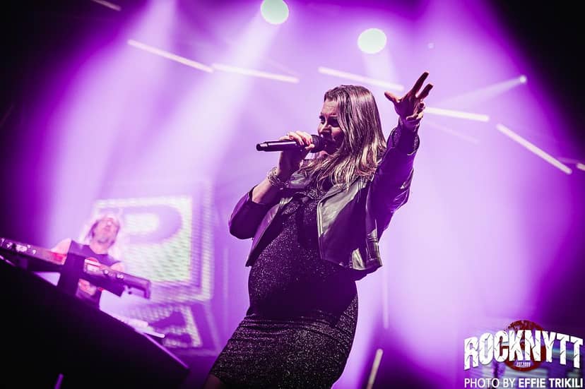 Live performance at E V E N E W arena with purple stage lighting, corporate event and concert.
