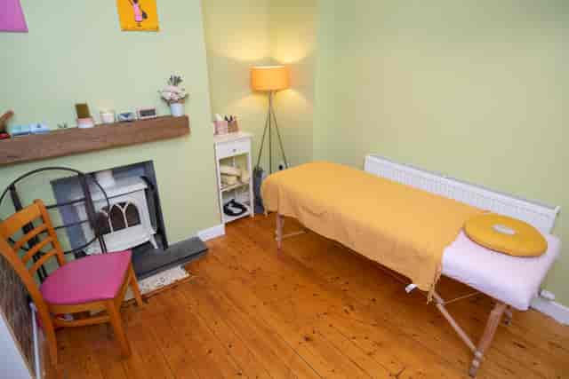 Wellness therapy room with massage table for holistic healing and mindfulness events.