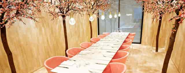 Bistro boardroom with cherry blossom canopy for VIP dinners and creative off-sites.