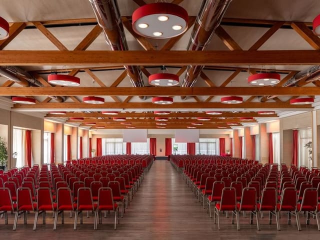 Theater-style conference room at Fiera Milano with exposed timber beams for corporate events.