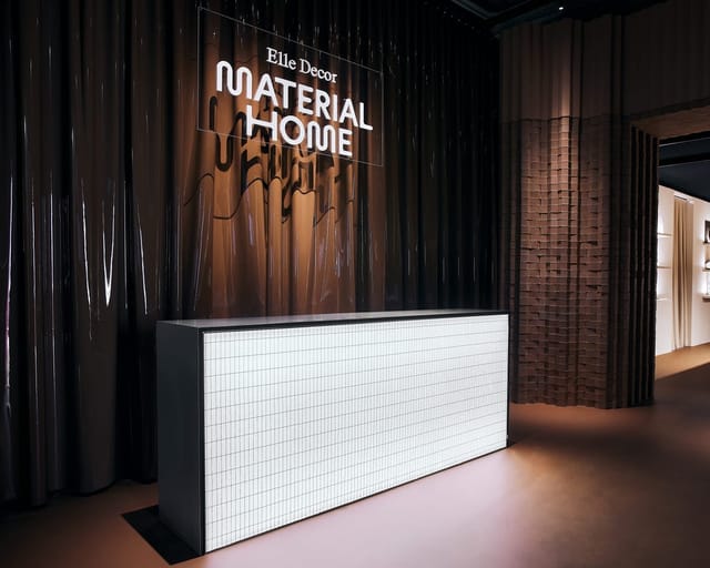 Minimalist registration desk with illuminated panel at Palazzo Bovara corporate event.