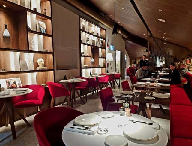 Isola Ristorante, Palazzo Cordusio: Red seating in upscale venue for corporate dinners, networking.