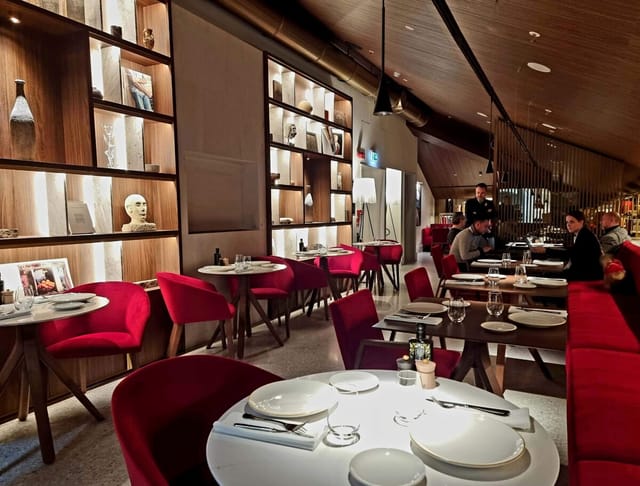 Isola Ristorante, Palazzo Cordusio: Red seating in upscale venue for corporate dinners, networking.