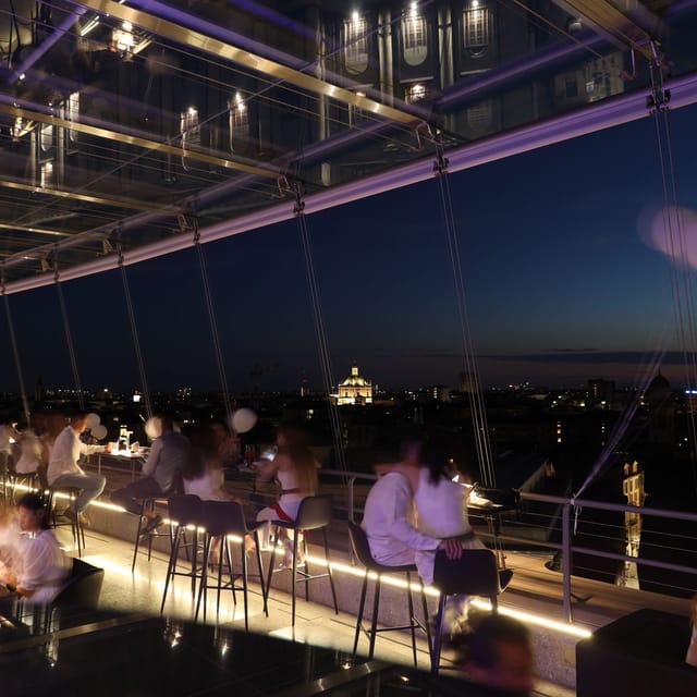 Rooftop networking event in Milan with panoramic skyline views and sophisticated lighting.
