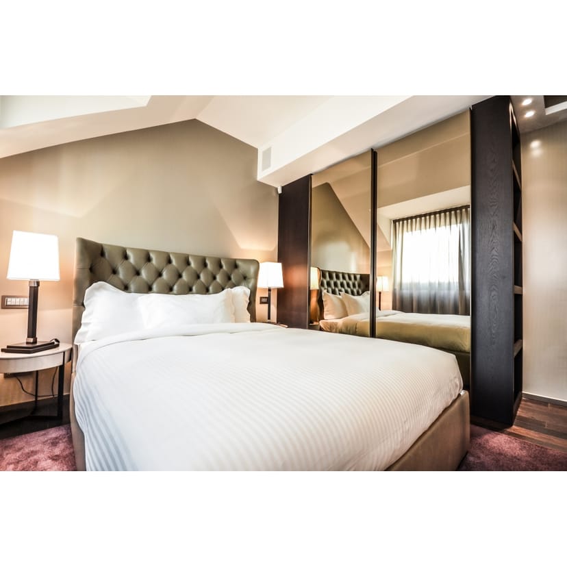 Luxury hotel room with tufted headboard for executive event and VIP accommodation.