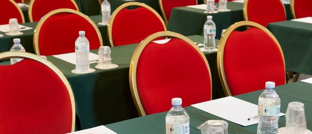 Classroom-style dining room setup with red chairs for corporate workshop or seminar.