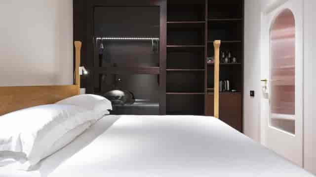 Modern hotel room with minimalist decor, ideal for executive travel and event room blocks.