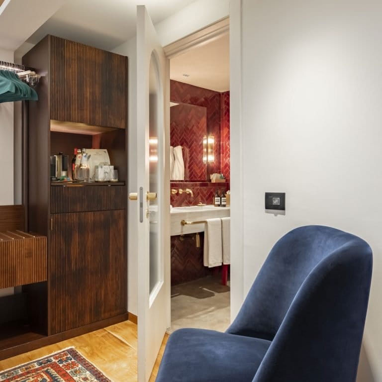 Luxury Vico Milano hotel room with velvet chair for executive stays and VIP event accommodation.
