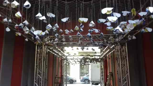 Truss entrance with hanging paper decor for event venue and architectural design.