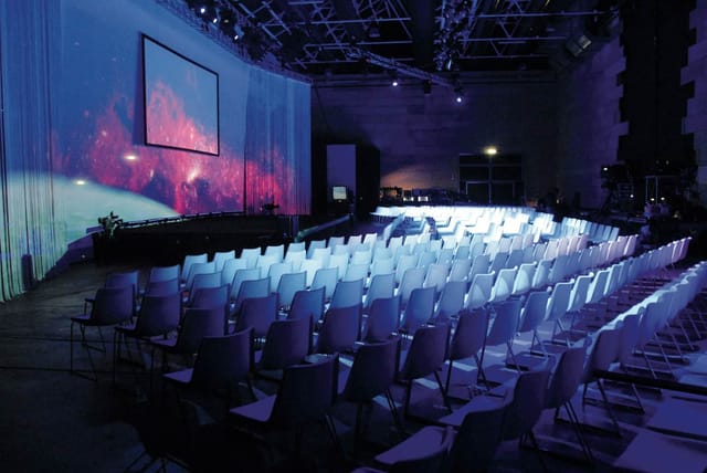 Industrial venue stage at Spazio Litometalli with projection mapping for corporate events and galas.