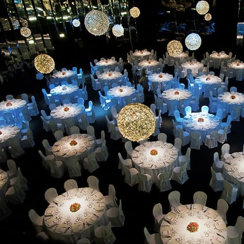 Gala event setup with round tables and sculptural lighting for professional event management.