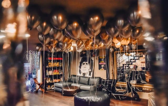 Industrial loft venue with metallic balloon ceiling for intimate event and party decoration.