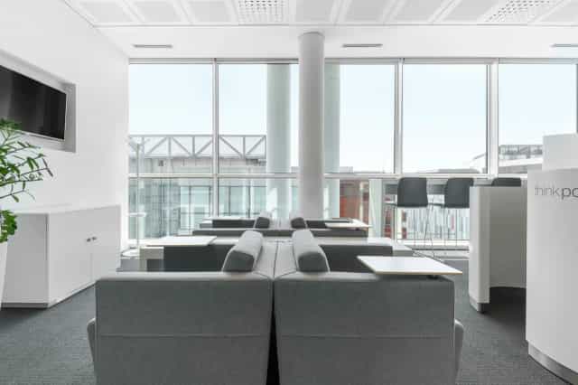 Modern business center breakout space with soft seating for corporate networking and events.