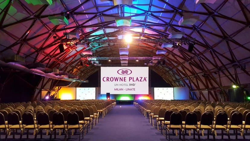 Theater-style conference room with dome ceiling and AV screens for corporate events and seminars.