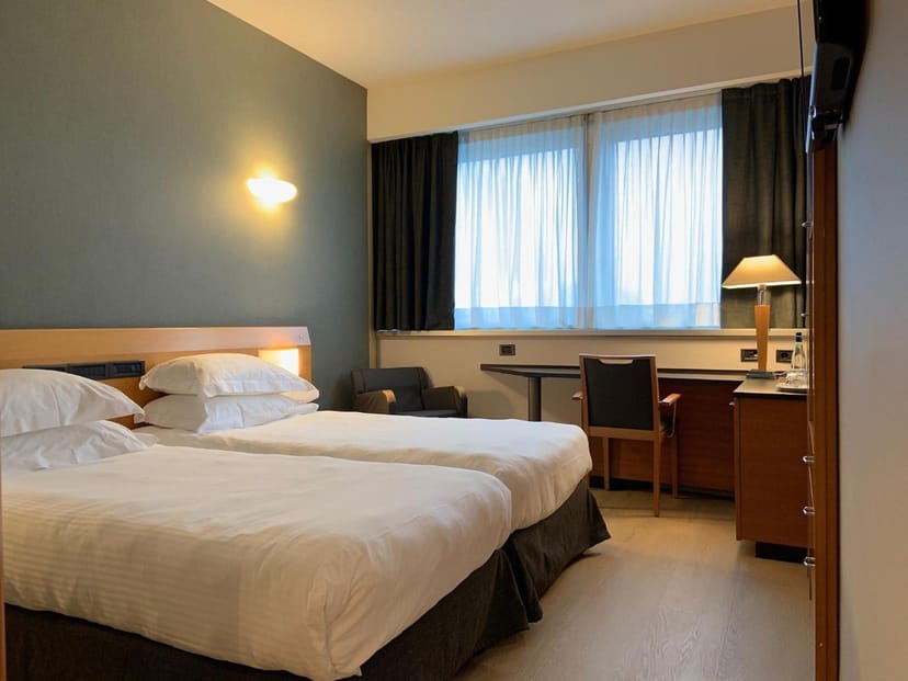 Twin guest room with workspace at Crowne Plaza Milan Linate, ideal for corporate event lodging.