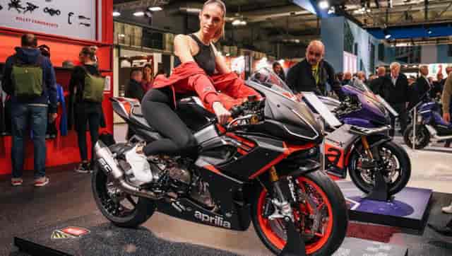 Brand ambassadors at EICMA trade show showcasing premium products at exhibition booth.