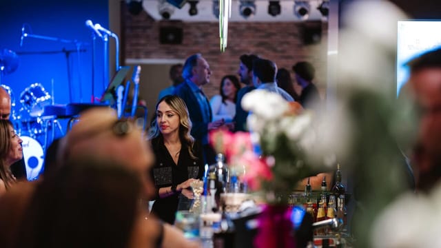 Corporate evening reception at Studio 26 with stage lighting for professional networking events.