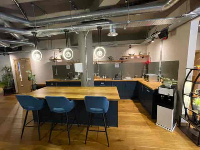Industrial breakout space with high-top table for corporate networking and team events.