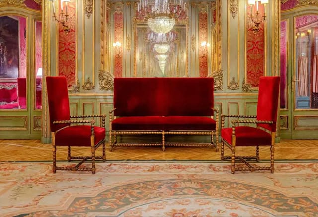 Elegant meeting room at Grand Hotel Plaza with plush red sofa, ideal for networking events.