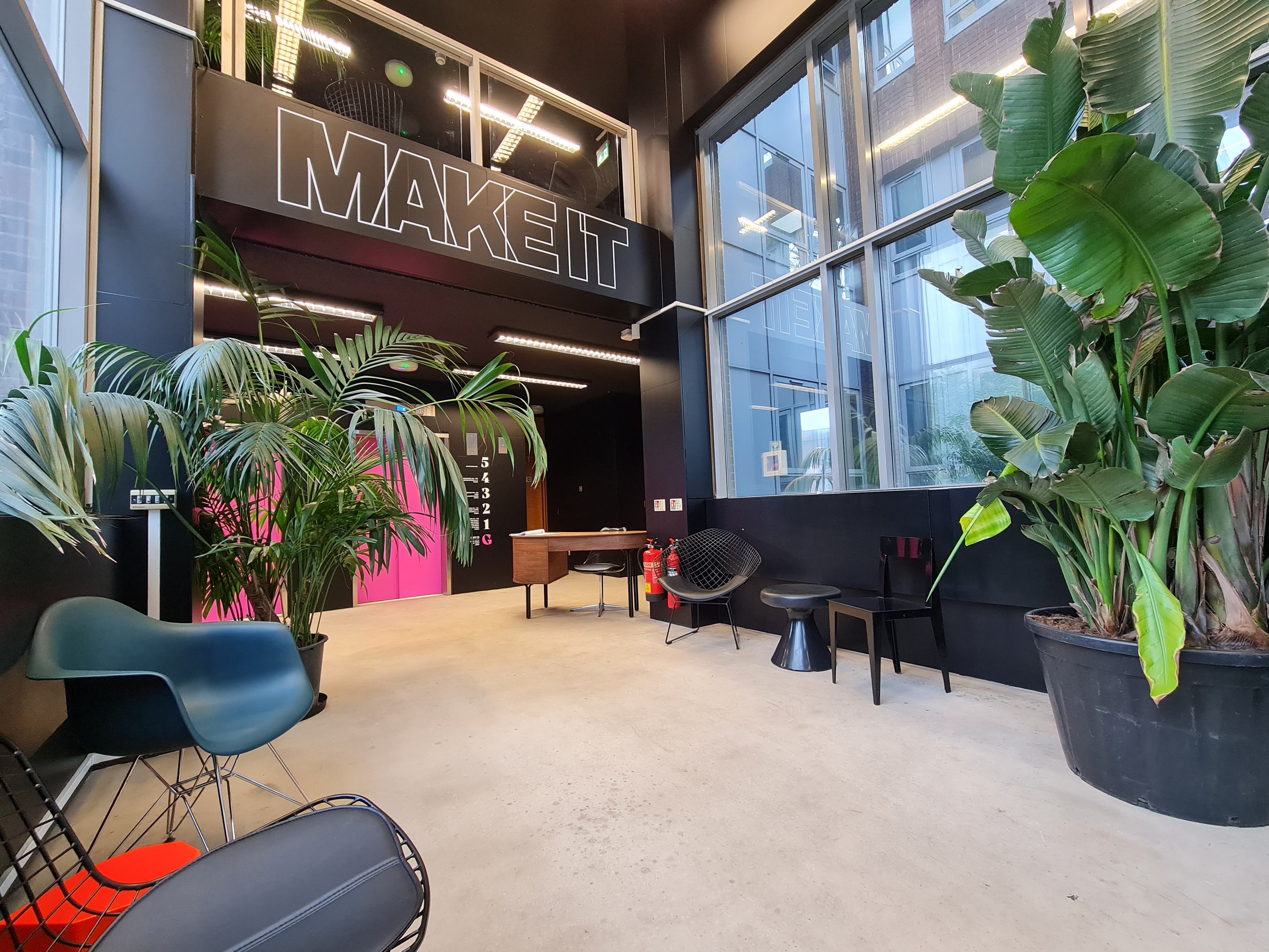 Modern event space at MAKE IT Barking with bold mural, perfect for networking and meetings. - Banner