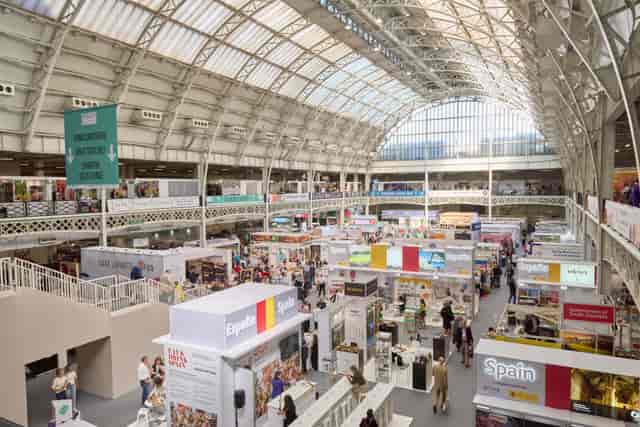 Vibrant exhibition hall in Olympia with cultural booths for networking events.