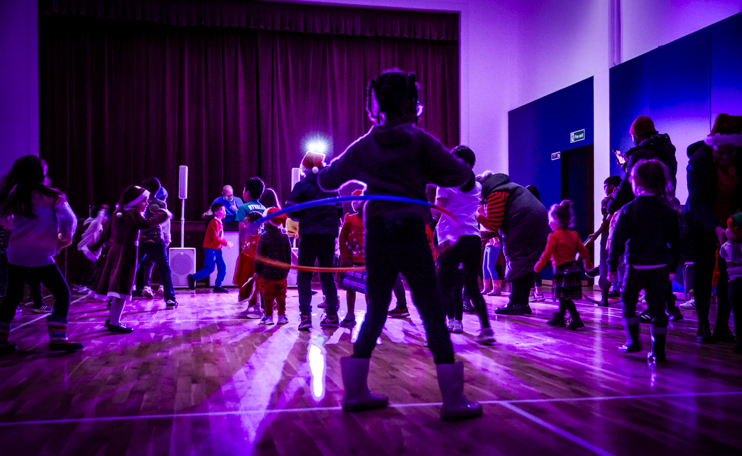 Children enjoying a hula hoop event in the vibrant Sports Hall at The Pyramid.