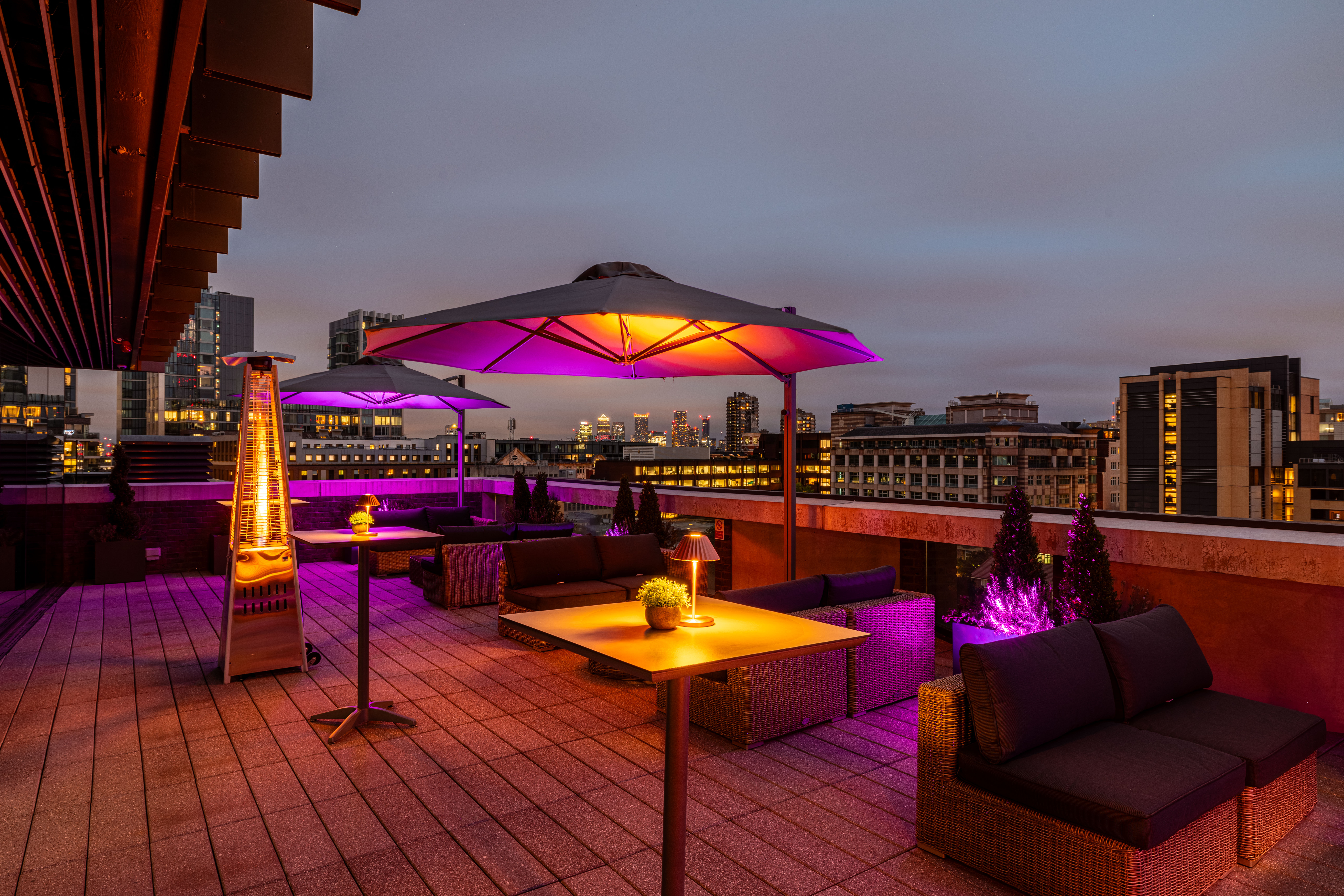 Stylish rooftop venue with city skyline for upscale summer parties and events. - Banner