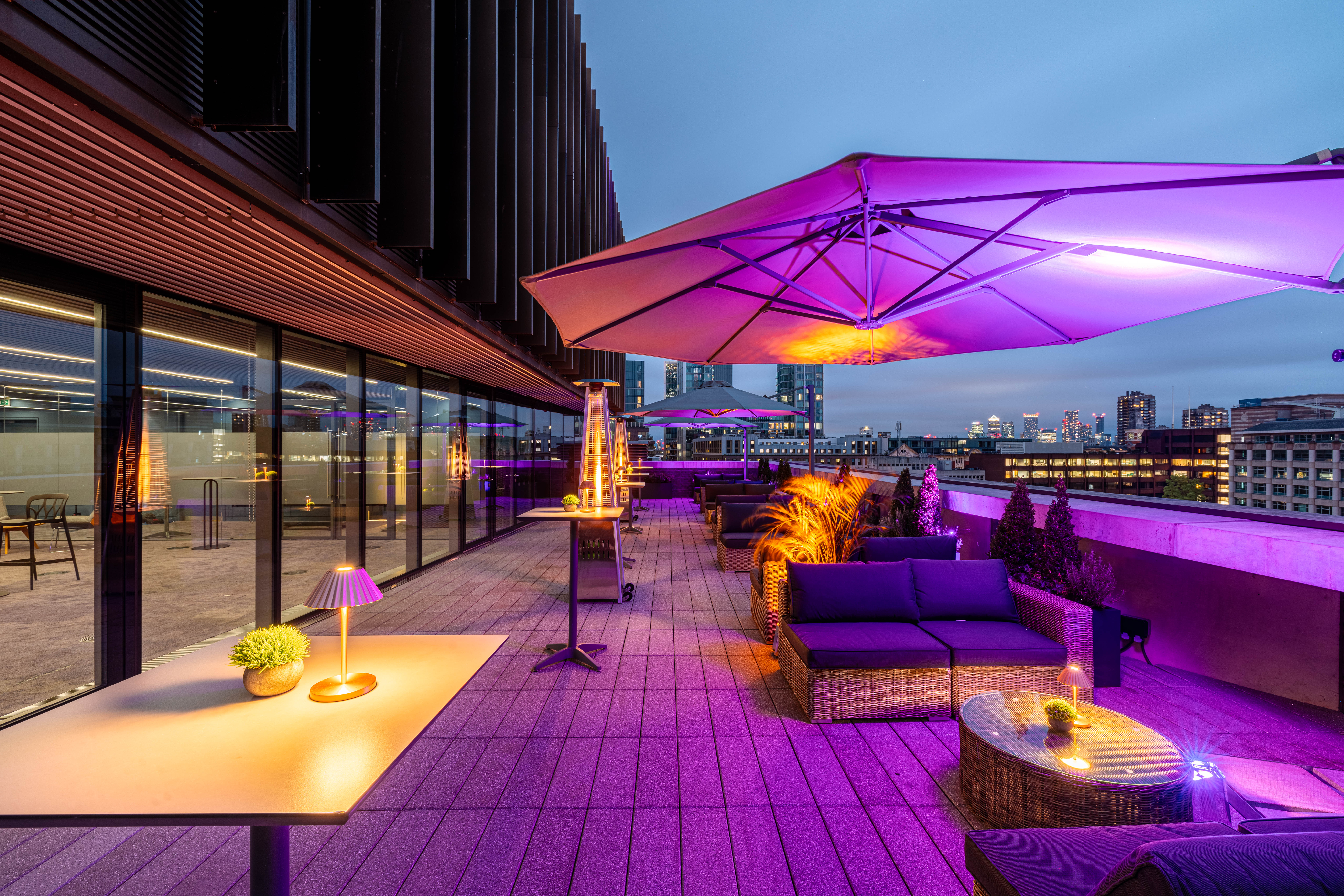 Stylish rooftop summer party venue with city skyline, perfect for networking events. - Banner