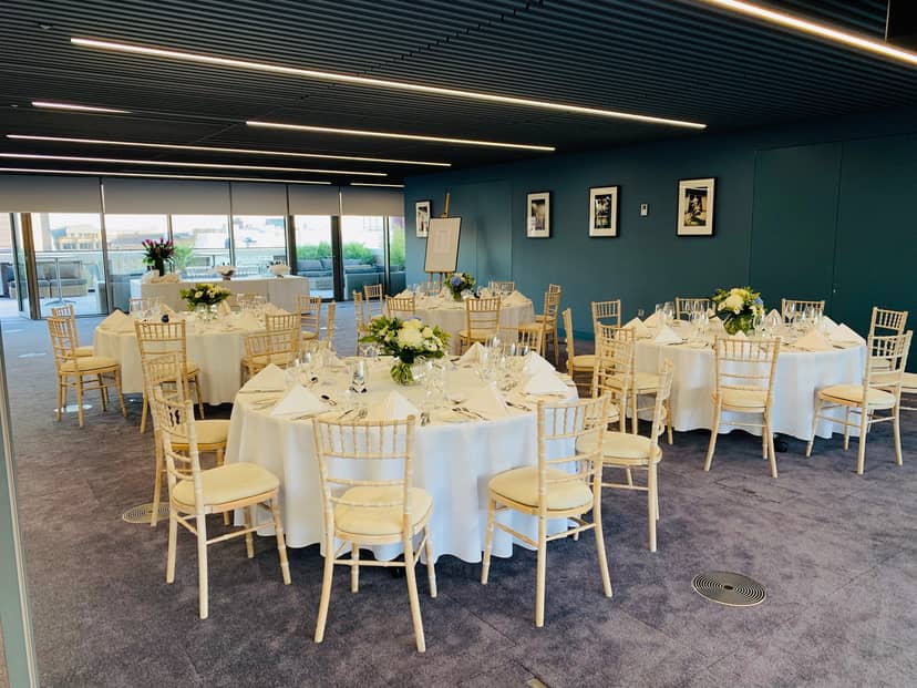 Summer Party Rooftop with elegant tables and floral centerpieces for corporate events.