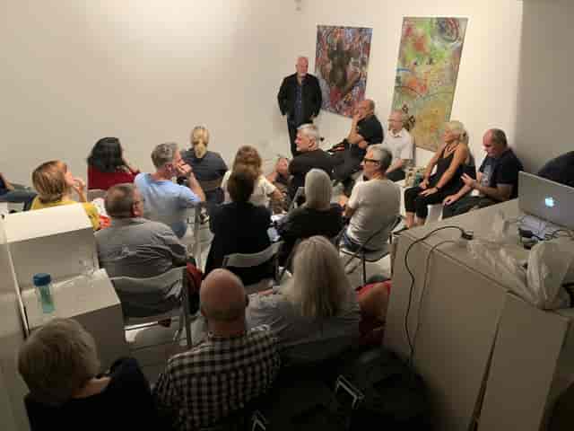 Intimate workshop at The Muse Gallery featuring speaker-led art talk and informal seating.