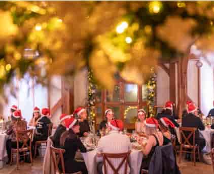 "Christmas party at Brookfield Barn with festive hats and elegant table arrangements."