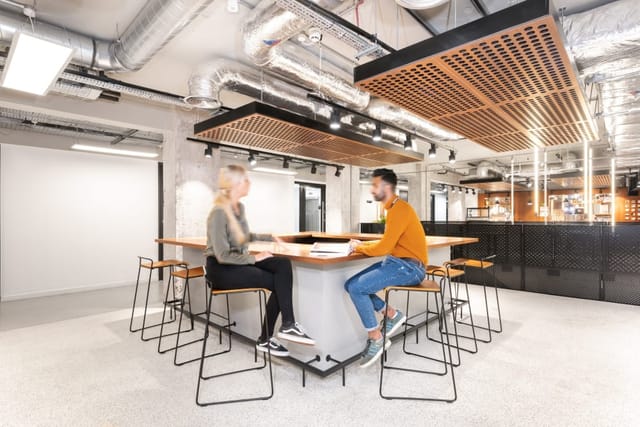 Industrial-chic meeting room with bar seating for collaborative brainstorming and networking events.
