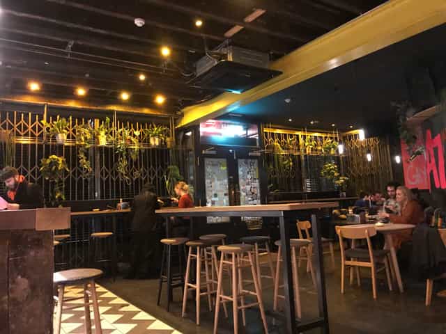 Industrial-chic bar with high-top tables for networking and casual event breakout sessions.