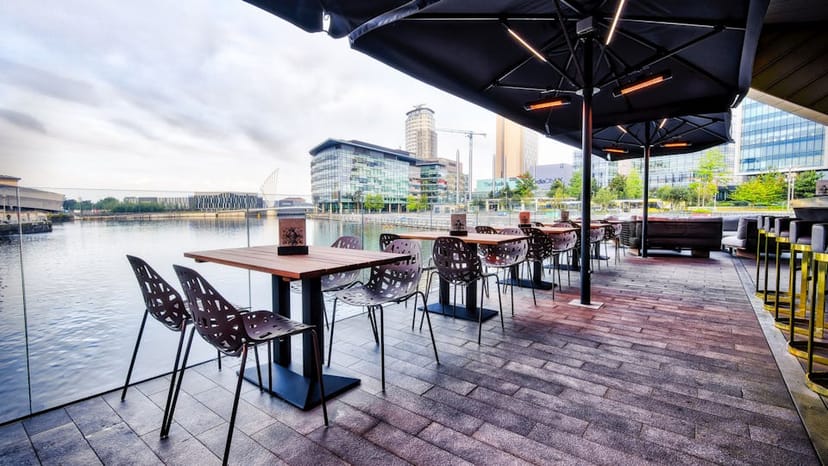 Outdoor corporate event space at The Alchemist with waterfront views and modular seating.