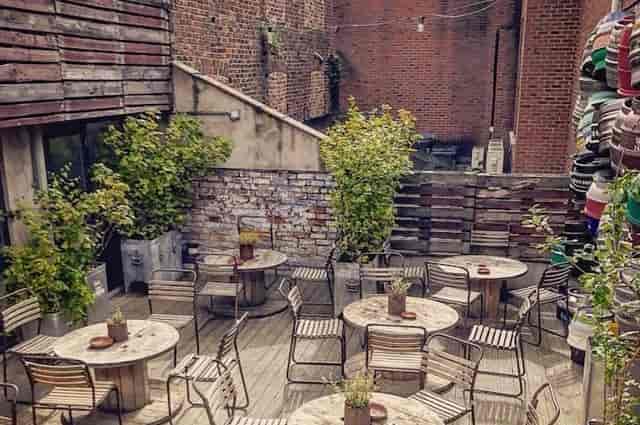 Industrial urban rooftop garden with modular seating for corporate breakout events.