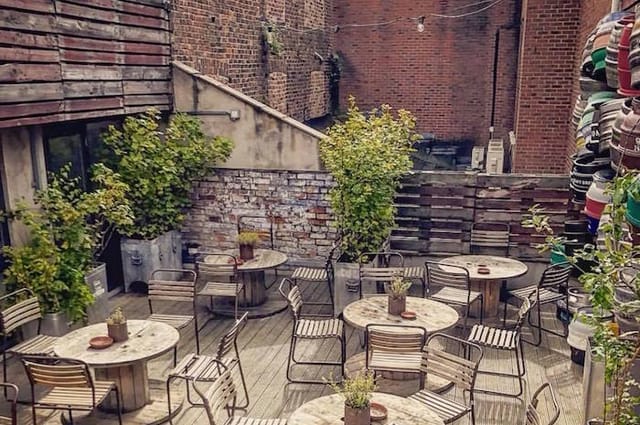 Industrial urban rooftop garden with modular seating for corporate breakout events.
