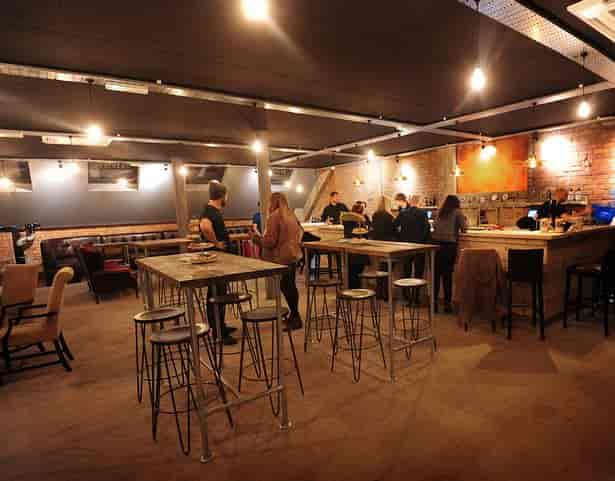 Industrial-chic Ancoats beerhouse with high-top tables for networking event mixers.