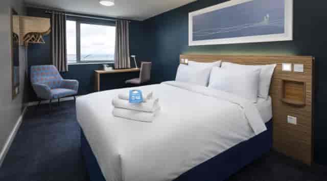 Modern hotel room with ergonomic desk for business travel and remote work.