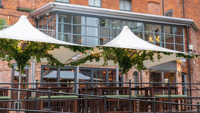 Industrial-chic beer garden with greenery for evening networking events and receptions.