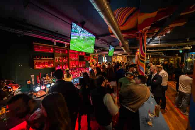 Sixes Cricket Games Bar interior with neon sports lounge decor, ideal for corporate team building.