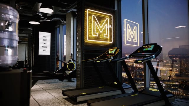 Luxury hotel fitness center with neon branding and city views for corporate wellness events.