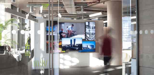 Modern industrial foyer at Contact Manchester featuring a large digital wall for event branding.