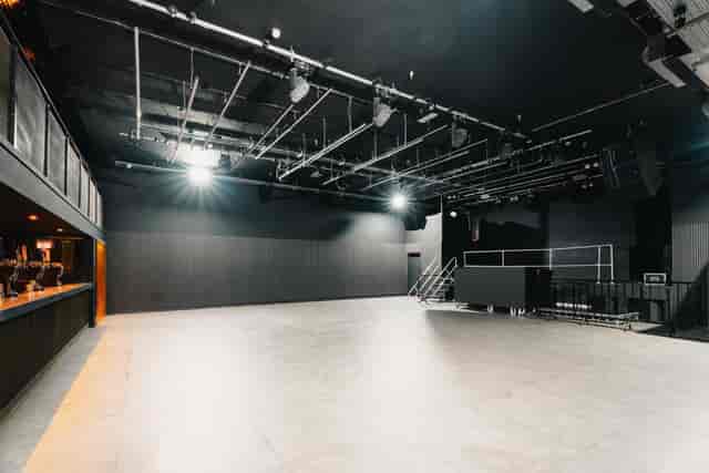 Industrial black box venue with overhead lighting for corporate events and brand activations.