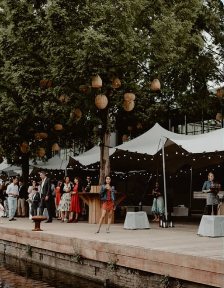 Jetty Bar outdoor stretch tent setup, atmospheric lighting, upscale corporate event venue.