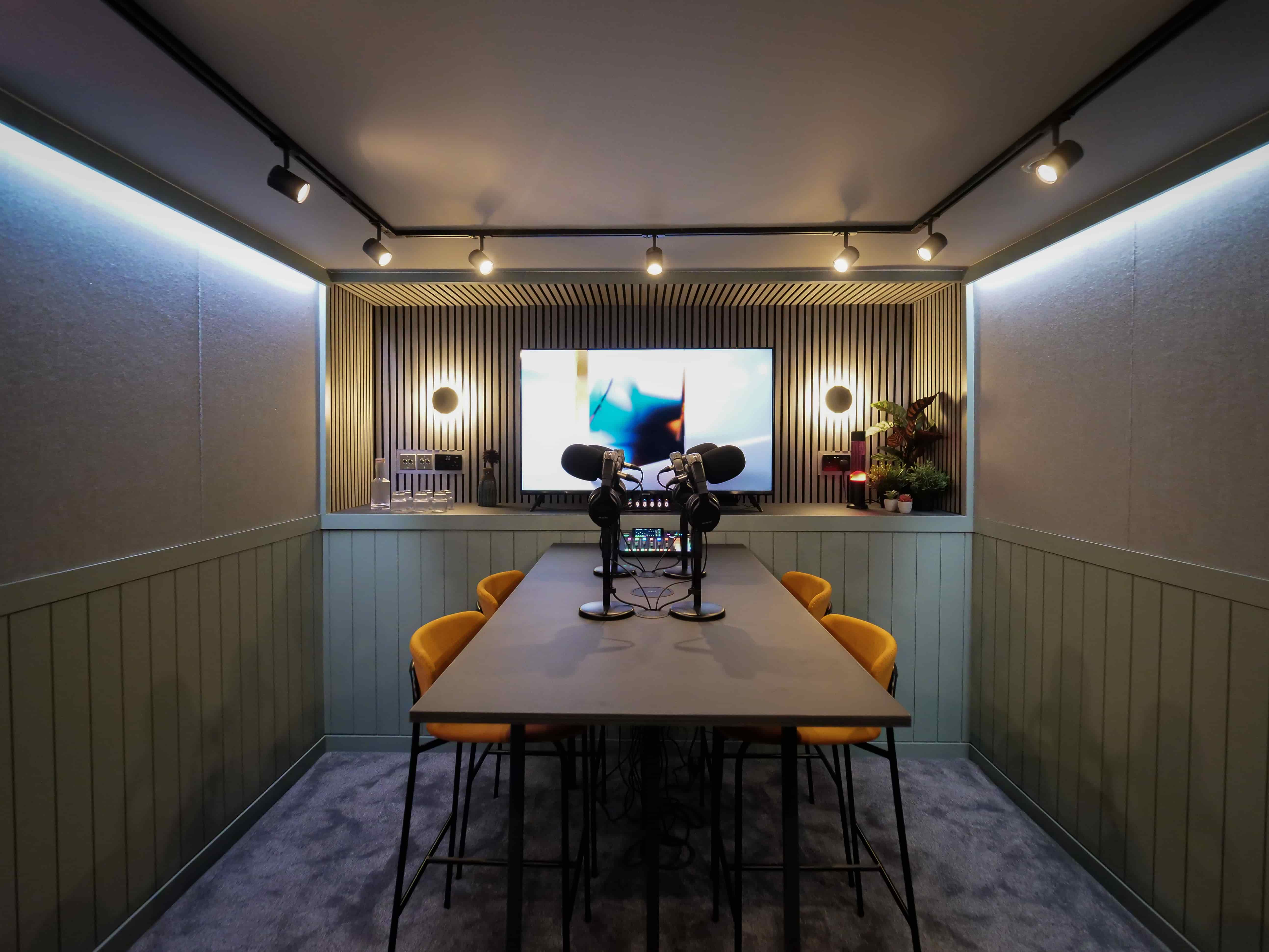 Modern podcast studio with vibrant chairs, ideal for creative meetings and content creation. - Banner