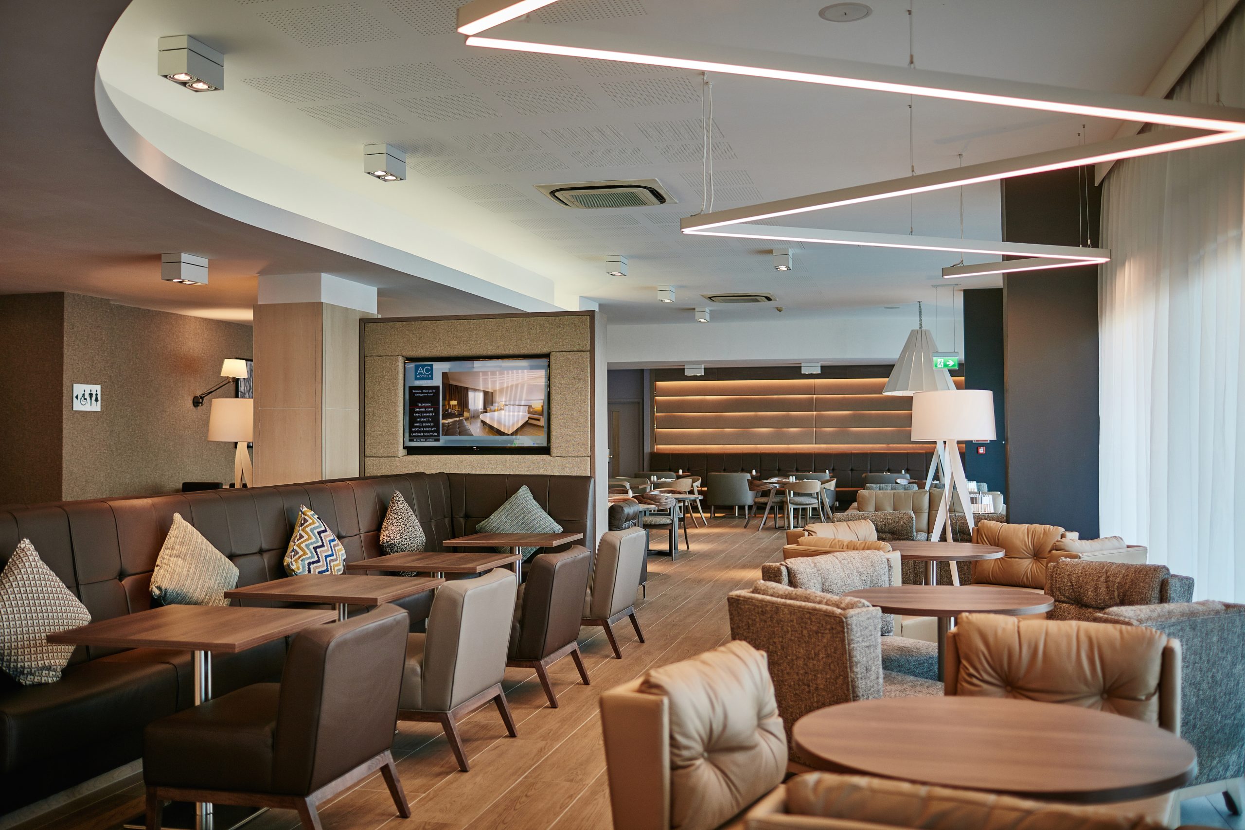 Modern lounge at AC Hotel Manchester for networking and meetings, featuring sleek design.