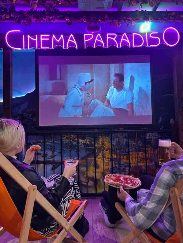 Cinema Paradiso projection screen with neon signage for retro experiential events.