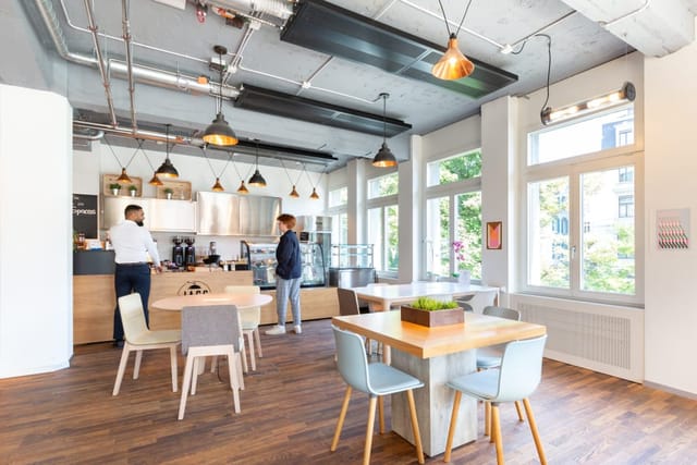 Modern coworking breakout area with coffee bar for networking and collaborative brainstorming.