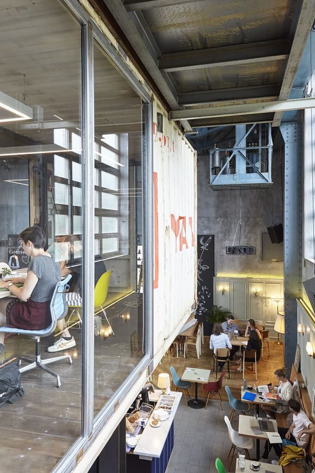 Industrial co-working space with meeting pods for professional workshops and networking events.