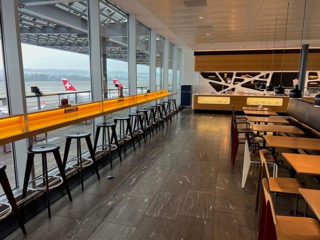 Zurich Development Center airport lounge with tarmac views for business events and productivity.
